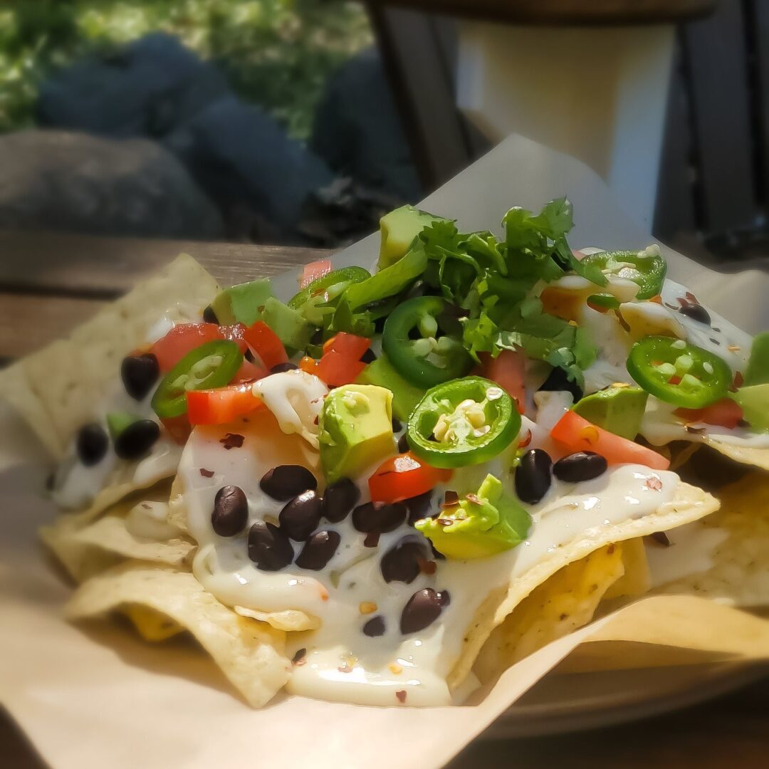 A plate of nachos with cheese, black beans and jalapenos.